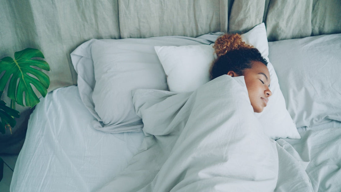 Vrouw slaapt rustig onder een verzwaard deken — diepe drukstimulatie voor wie een verzwaard deken het beste werkt