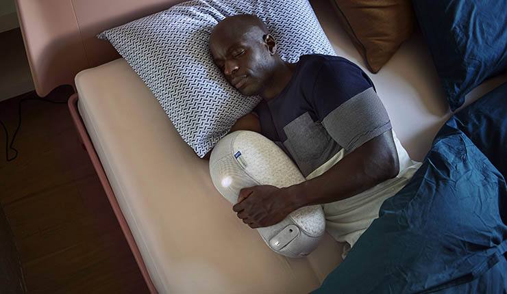 Man slaapt met Somnox slaaprobot — innovatieve slaaptechnologie die ademhaling simuleert voor diepere ontspanning en betere slaap