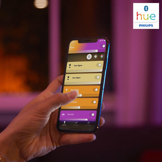 philips hue iris lamp app op een mobiele telefoon die vastgehouden wordt door een hand