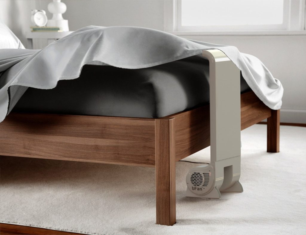 Bfan bed ventilator naast een bed die lucht blaast onder een deken