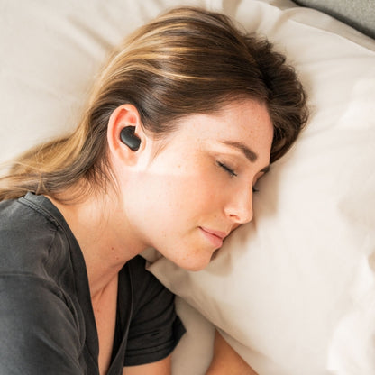 Slapende blonde vrouw met de innovagoods bluetooth slaap oordopjes in haar oor